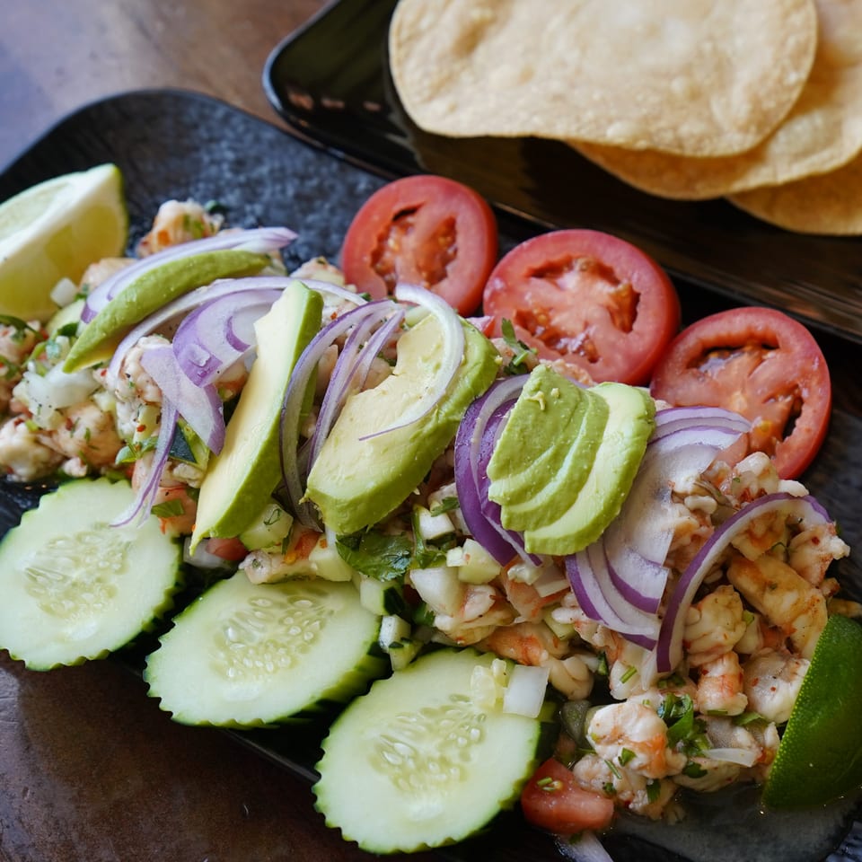 Lempira Restaurant's shrimp ceviche with avocado, red onion, cucumber, tomatoes, and lime, served with tostadas.